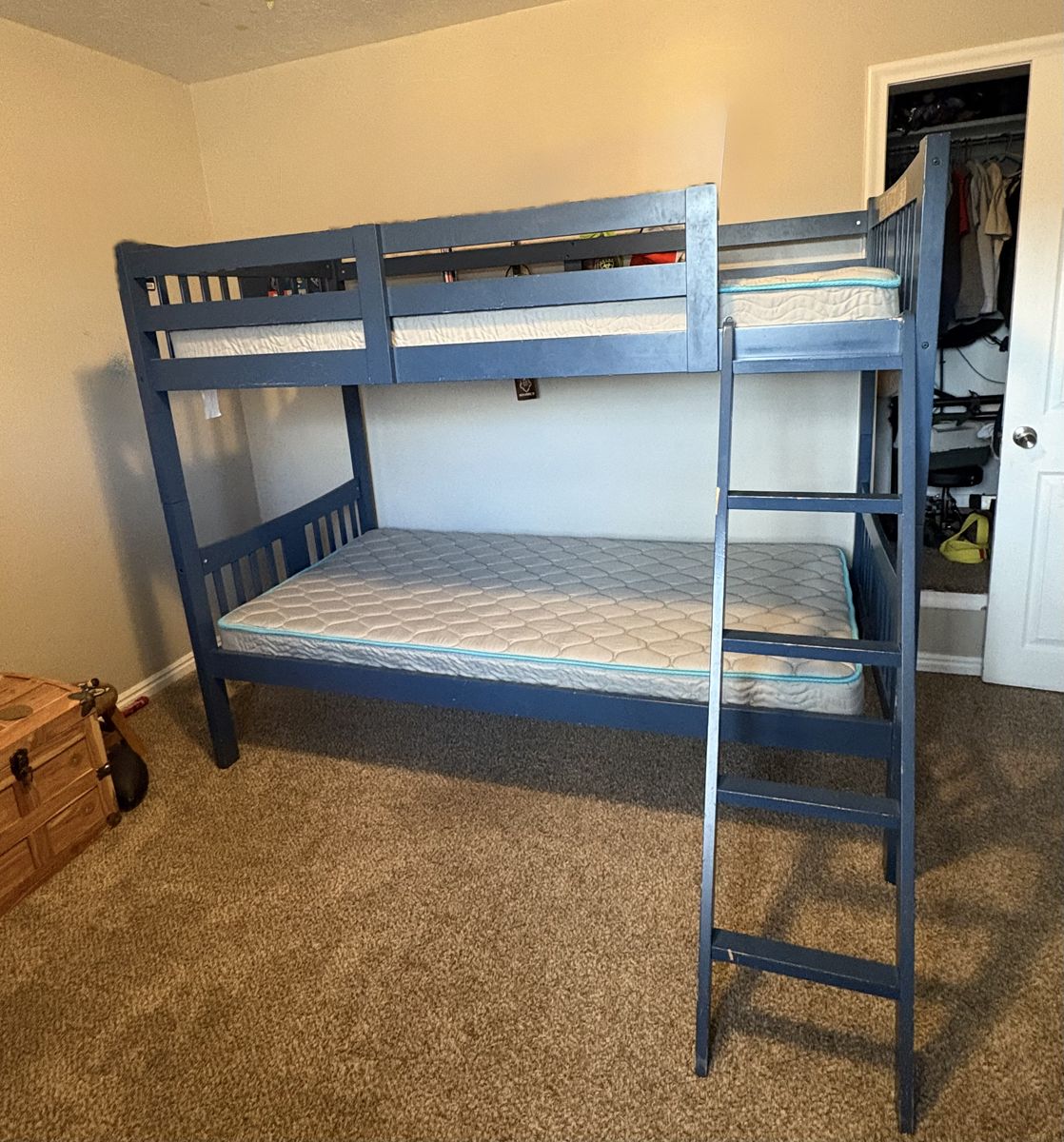 Twin bunk beds with ladder and mattresses