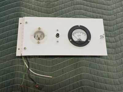 Gauge panel with fused outlet