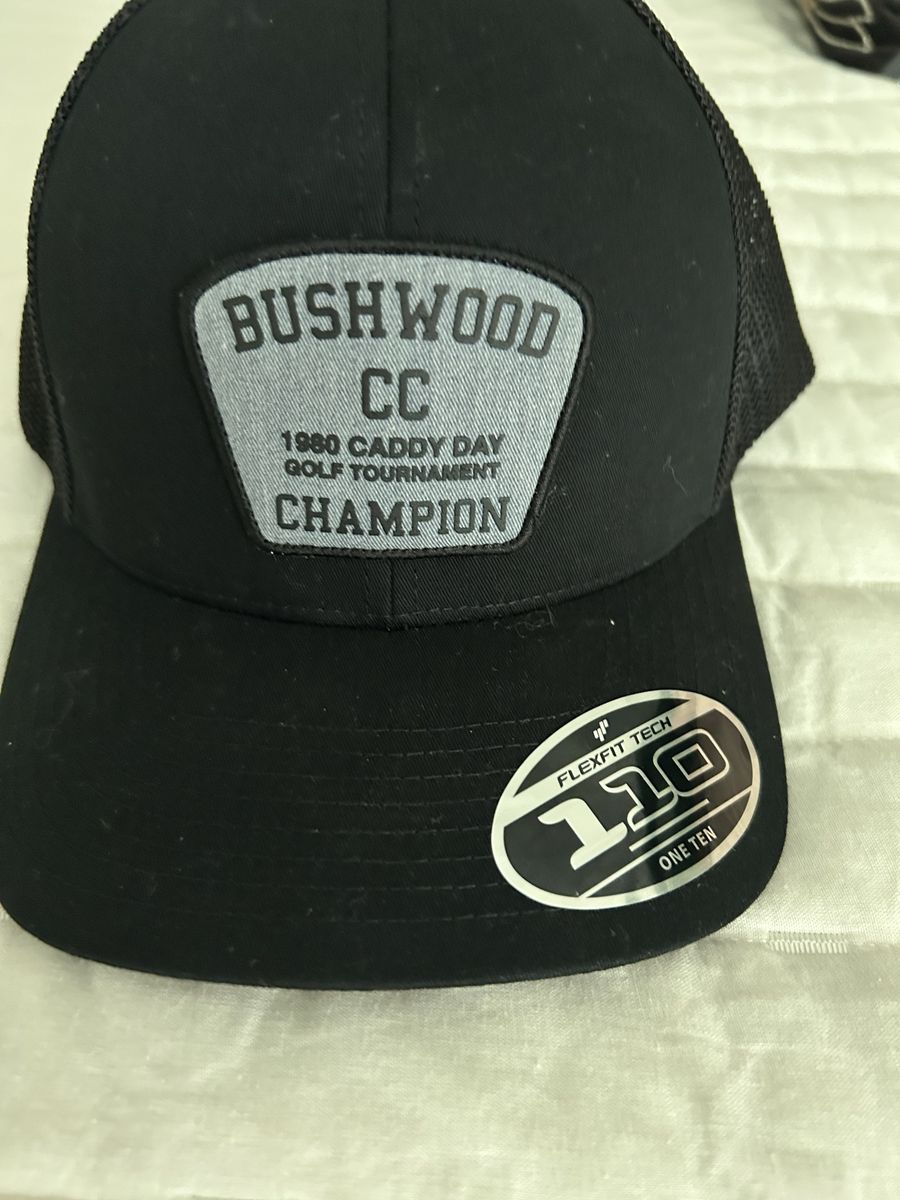 Travis Matthew’s Bushwood CC 1980 Caddy Day Golf Tournament Champion Flexfit 110 Trucker Hat