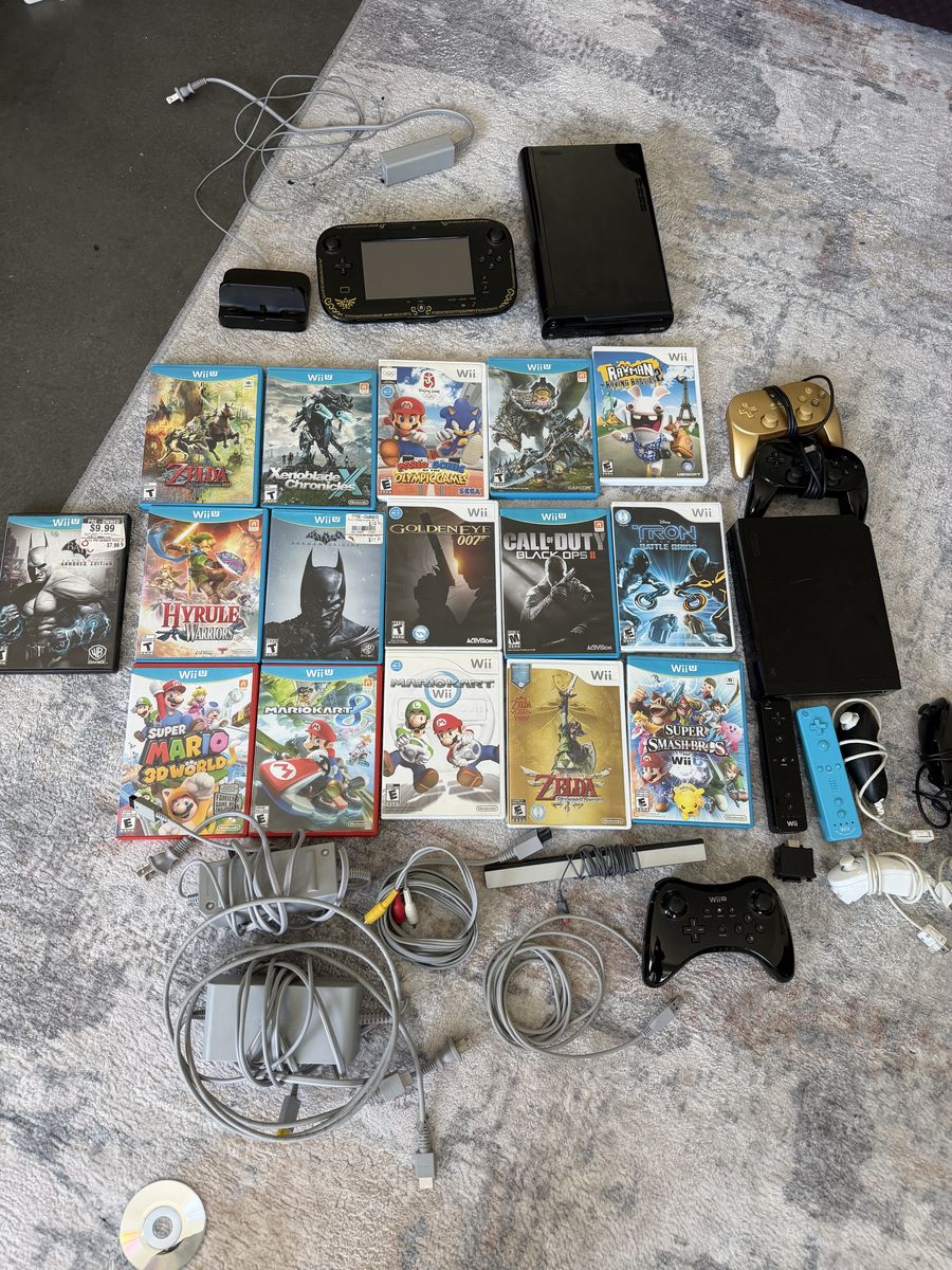 Black Wii console, black Wii U Console with Legend of Zelda Wind Waker themed gamepad with games