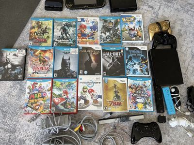 Black Wii console, black Wii U Console with Legend of Zelda Wind Waker themed gamepad with games