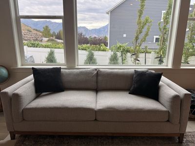 Light Gray Fabric Sofa with Wooden Base Frame and Accent Pillows