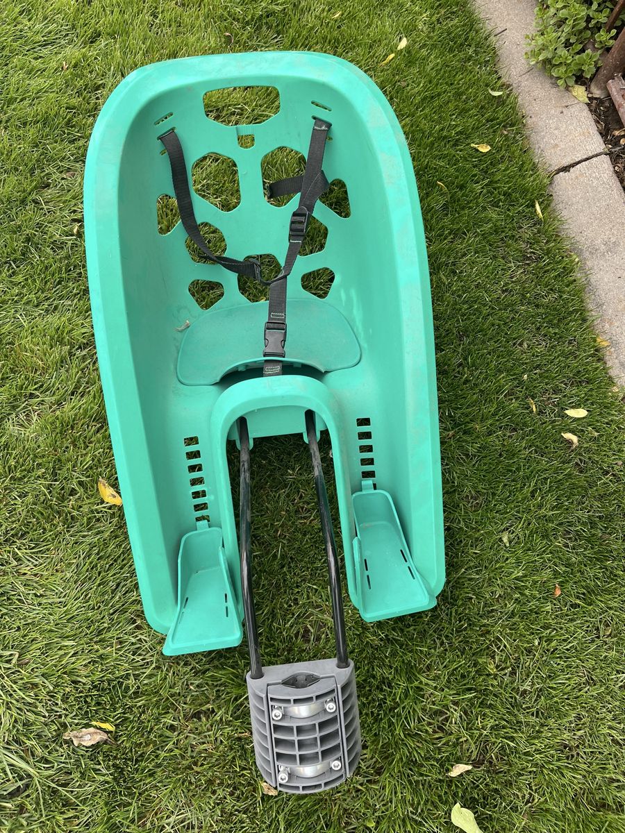 Green Childs bicycle seat attachment with adjustable foot rests.