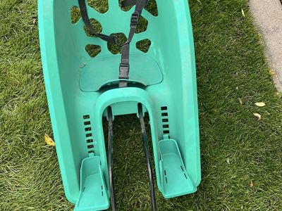 Green Childs bicycle seat attachment with adjustable foot rests.