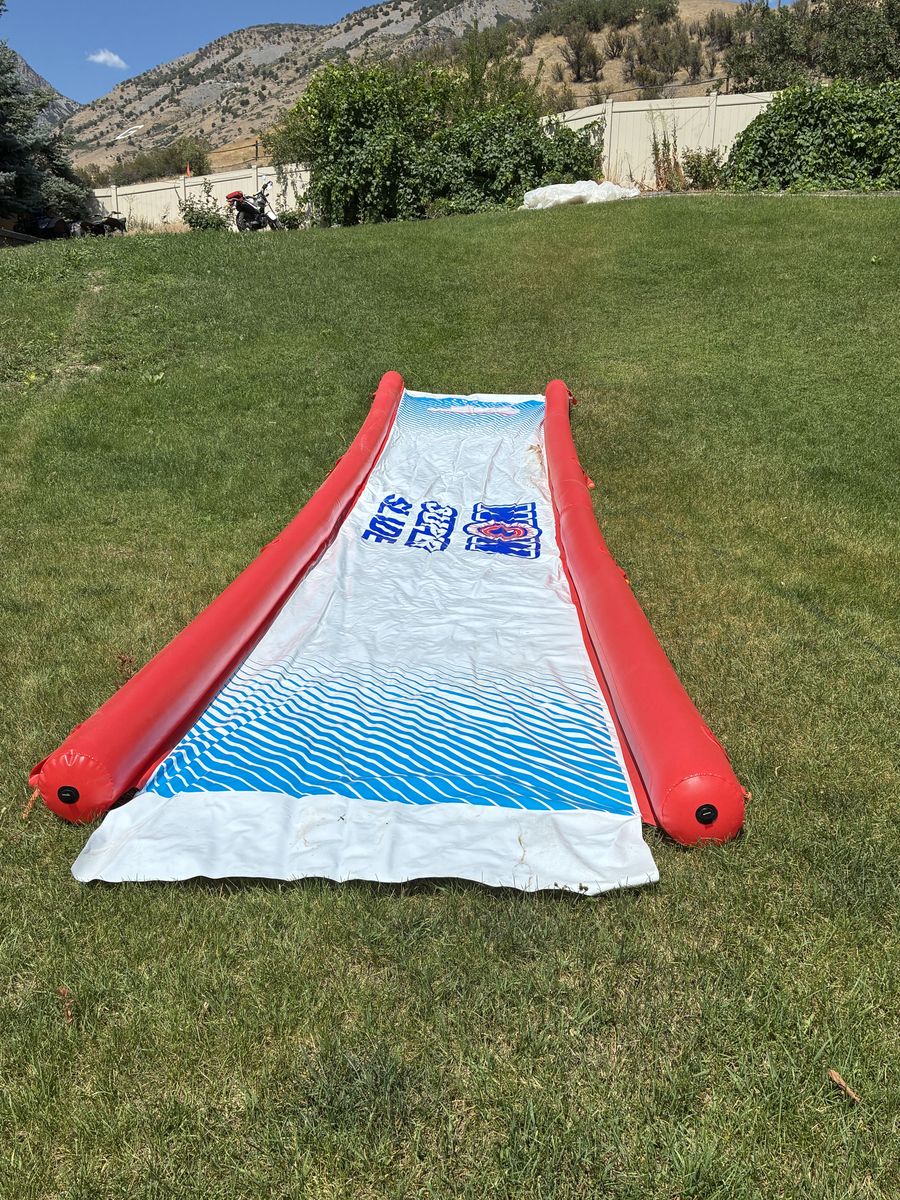 Giant 25' slip n slide with built in sprinklers and inflatable bumpers.