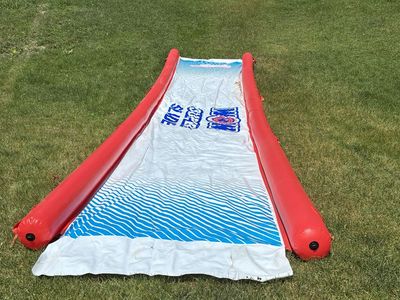 Giant 25' slip n slide with built in sprinklers and inflatable bumpers.