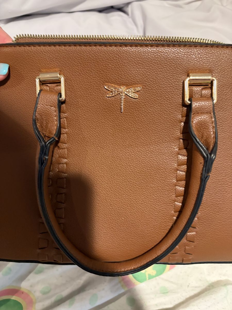 Purse with a dragon fly on the front and multiple pockets and spaces ￼