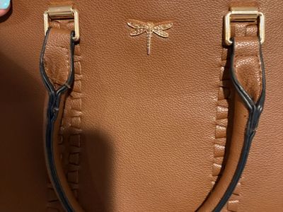 Purse with a dragon fly on the front and multiple pockets and spaces 