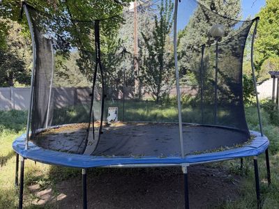 $100 - 12’ Trampoline with Net Enclosure and Hoop. Zipper broken.