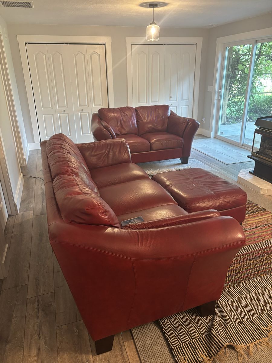Three piece Red Leather Living Room Set. (Couch, Ottoman and Love Seat