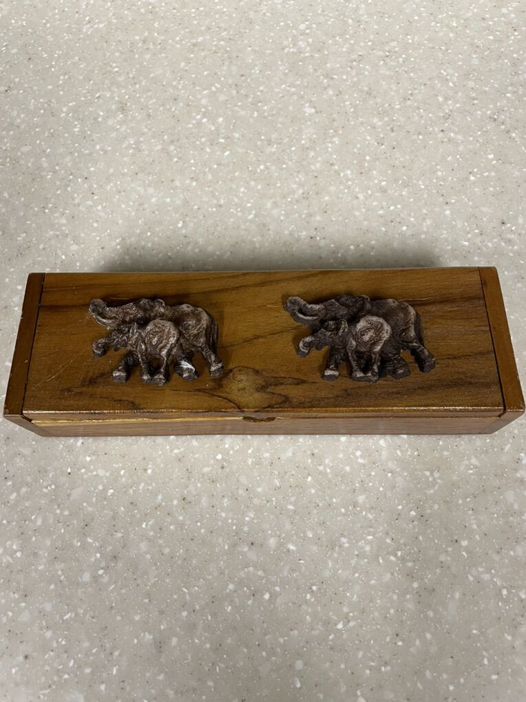 Thai teak wood box adorned with elephant carvings.