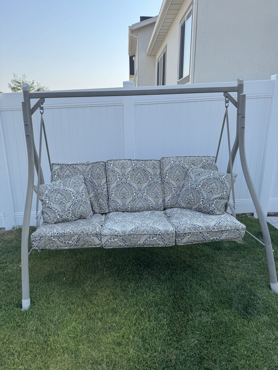 Outdoor Patio Swing with Patterned Cushions and Throw Pillows