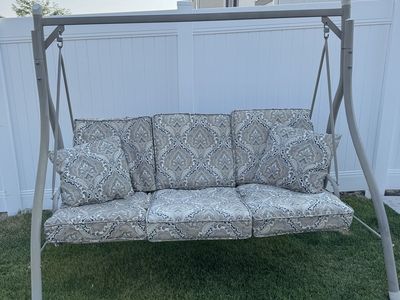 Outdoor Patio Swing with Patterned Cushions and Throw Pillows