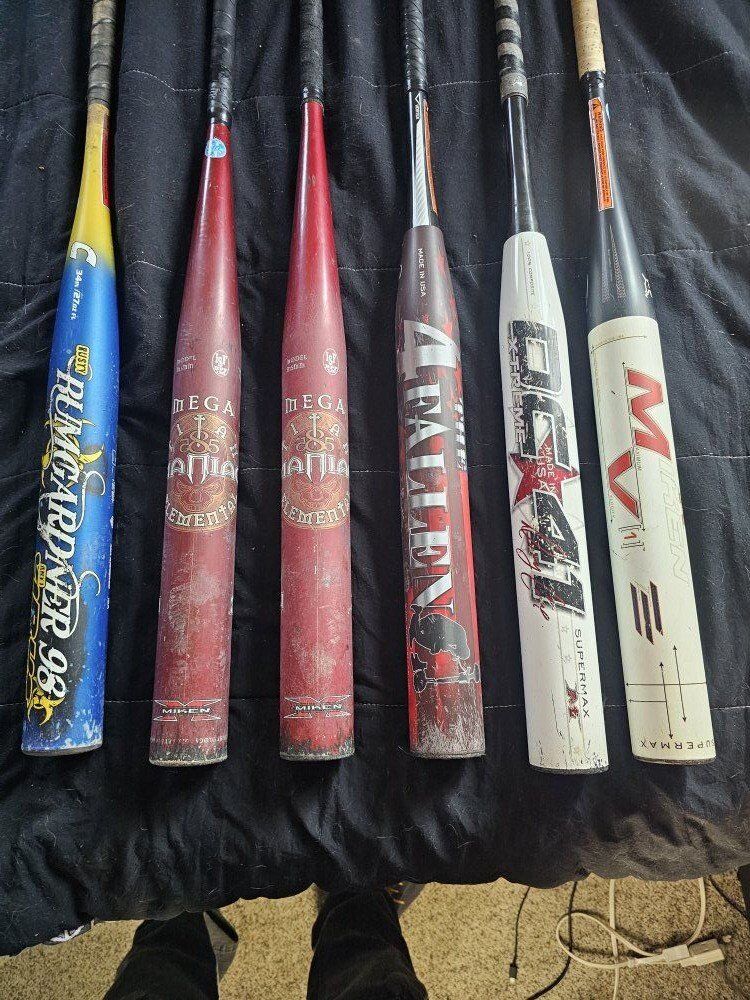 6 Softball bats and rolling bat bag