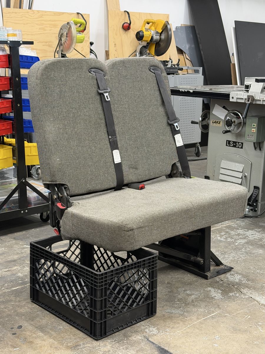Used Gray Two-Seater Fold Down Bench Seat with Seatbelts. Perfect for a van build.