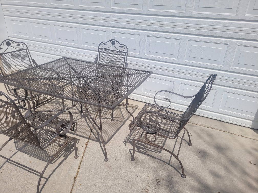 wrought iron patio table and 4 rocking chairs
