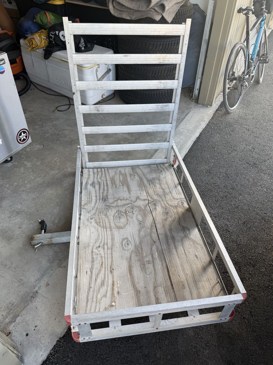 Trailer hitch storage rack with ramp