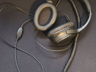 Headphones with volume control and coiled cable