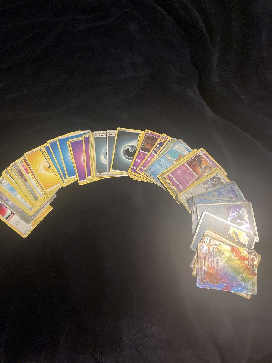 Assorted stack of Pokémon cards including trainers, energy, and pokemon