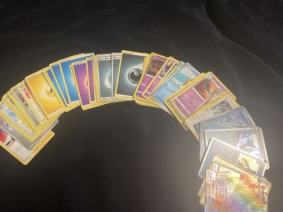 Assorted stack of Pokémon cards including trainers, energy, and pokemon