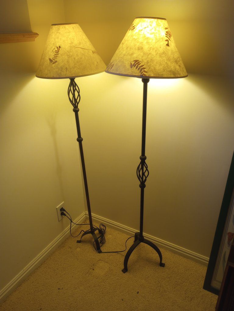 Two matching wrought-iron lamps with cloth shades.