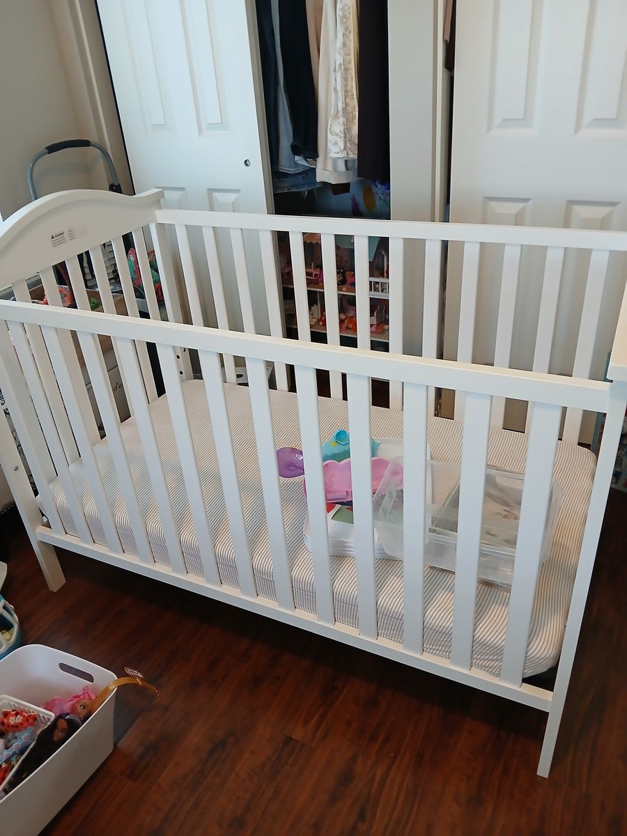 White wood crib with mattress.