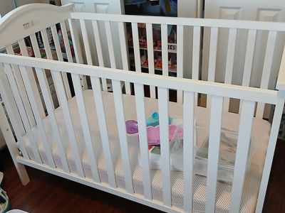 White wood crib with mattress.