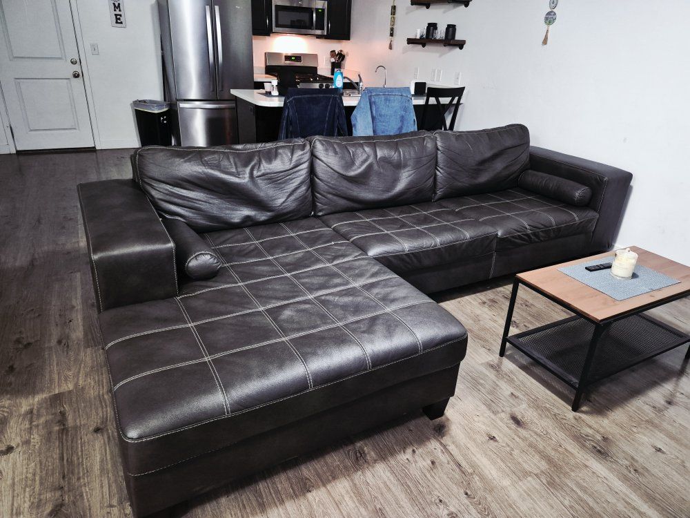 Dark Brown Faux Leather L-Shaped Sectional Sofa with little coffee table.