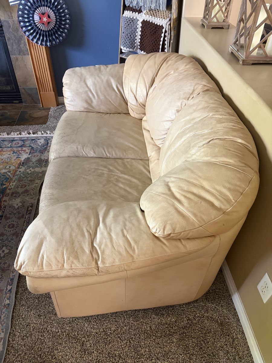Cream Leather Couch with Visible Wear and Tear. 