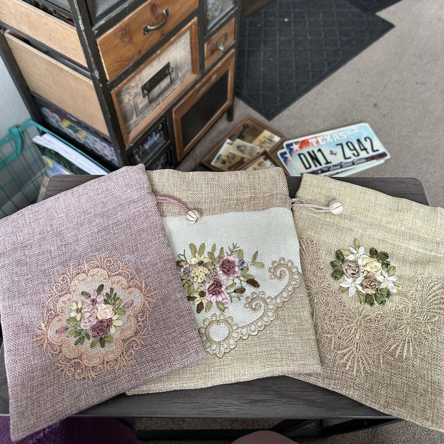 Three embroidered drawstring fabric bags