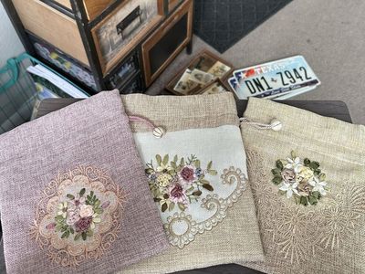 Three embroidered drawstring fabric bags