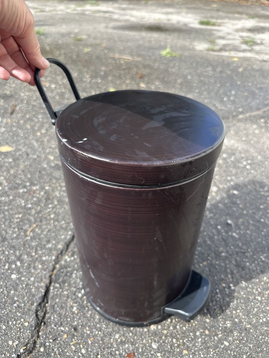 Small dark brown step trashcan with foot pedal and carrying/hanging handle