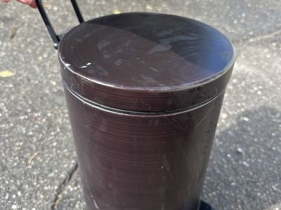 Small dark brown step trashcan with foot pedal and carrying/hanging handle