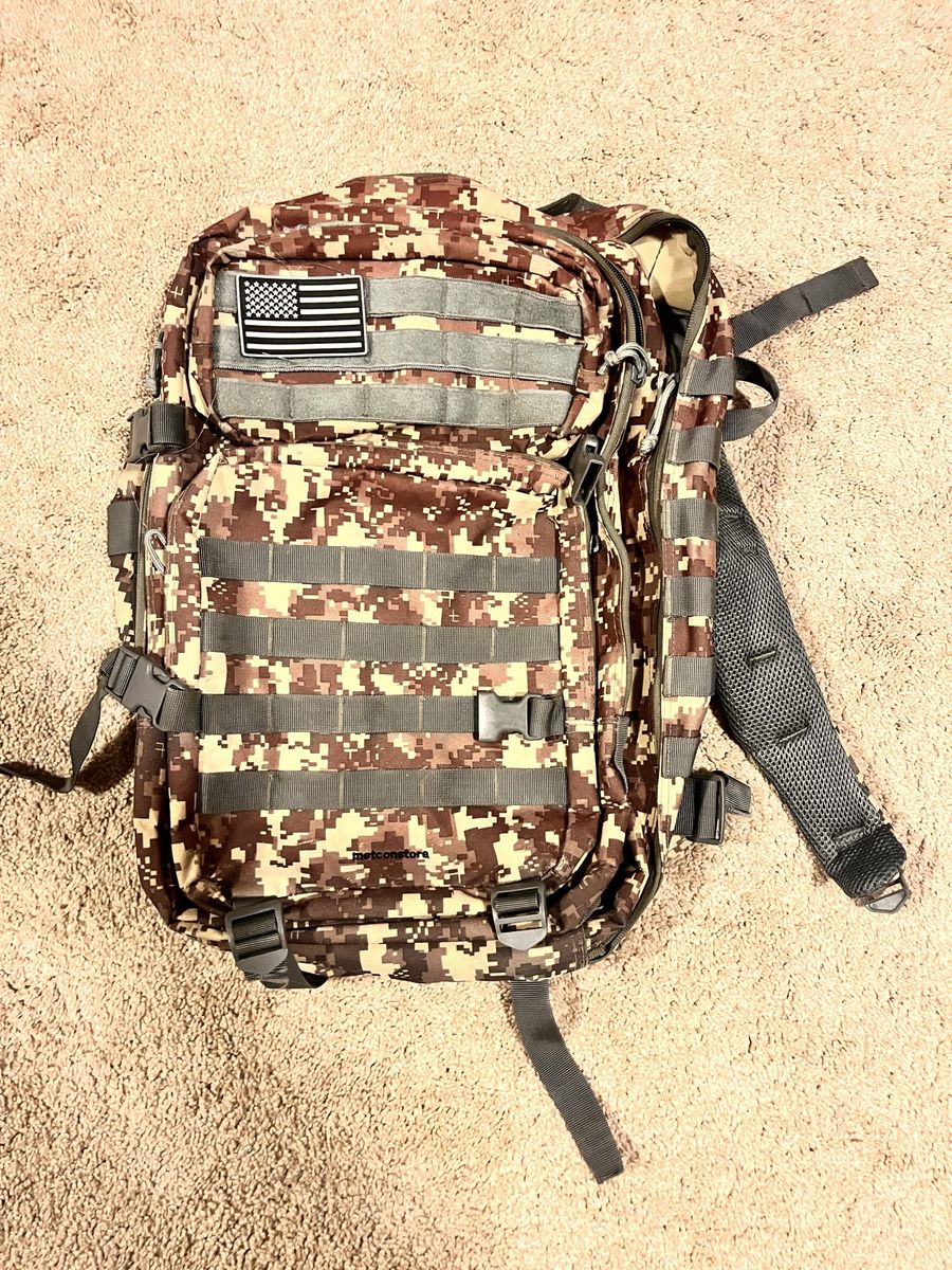 Camo backpack with American flag patch and many clips for school or outdoors
