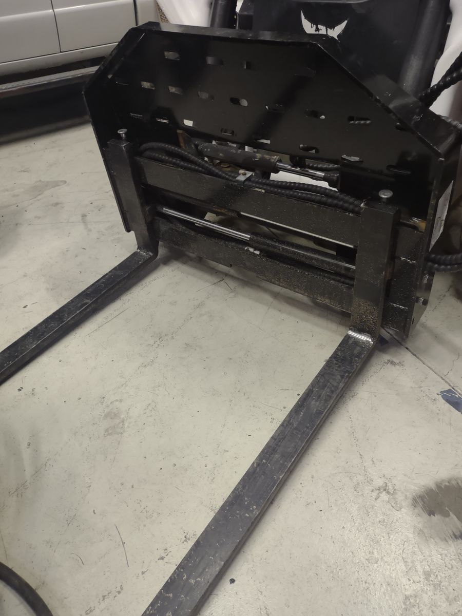 Skid steer hydraulic positioning pallet forks