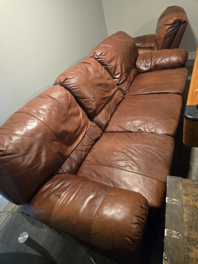 Spacious Brown/Orangish Leather Couch and Swivel/Rocking Single Chair - Comfortable Seating for Your Living Room