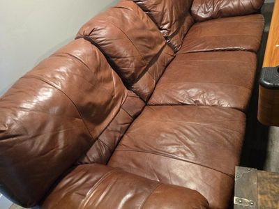 Spacious Brown/Orangish Leather Couch and Swivel/Rocking Single Chair - Comfortable Seating for Your Living Room
