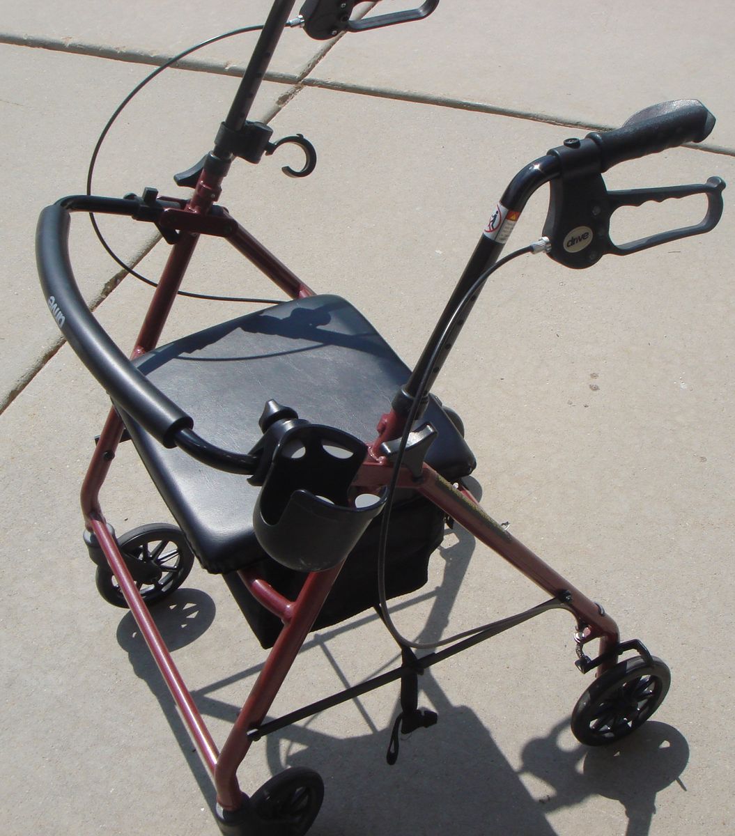 Drive Rollator Walker. Padded seat and backrest, locking breaks, storage area, folds up.