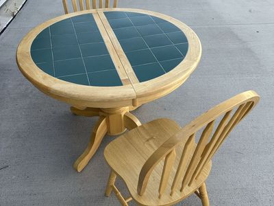 Wood and Tile expandable pedestal dining table and two oak chairs
