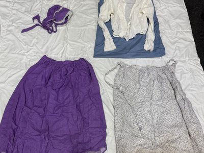 Purple pioneer skirt and bonnet with white blouse and color coordinated apron.