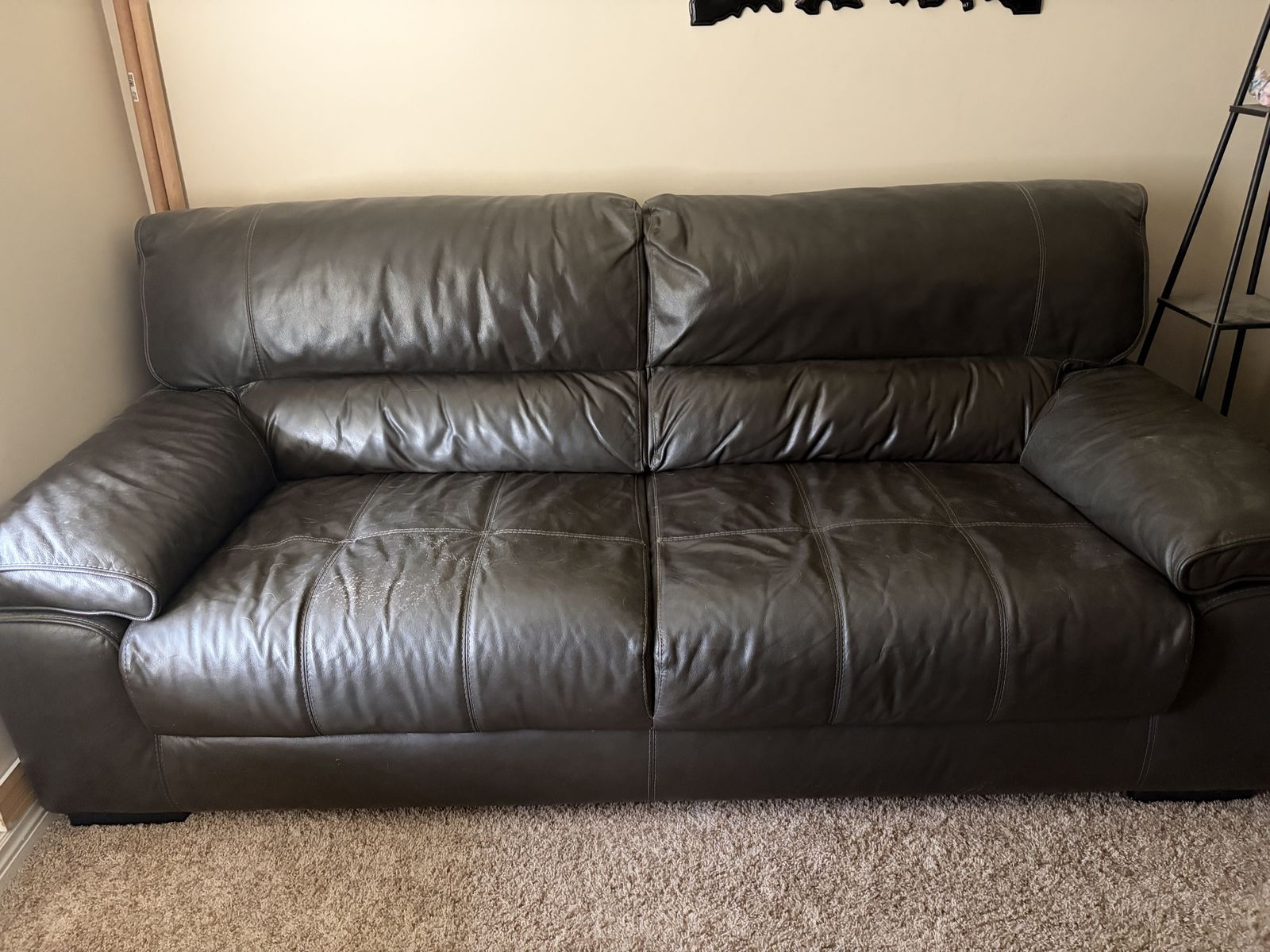 Dark Gray Vinyl Couch Sofa with Visible Wear and Scratch Damage