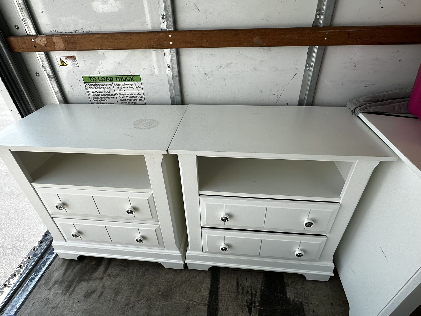 two large white wood nightstands. *one of them has paint defect on top surface*