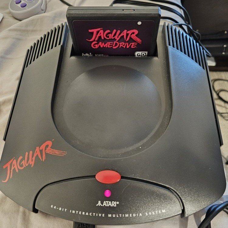 Atari Jaguar console with controller, game drive, and S-Video adapter
