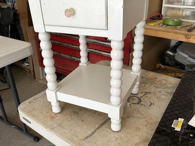 White Painted Wooden Nightstand with Spindle Legs and Lower Shelf