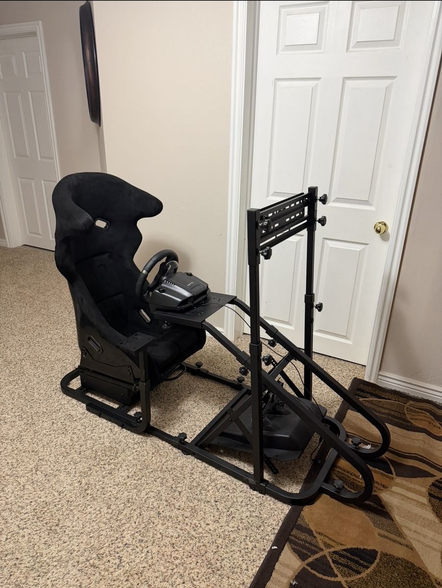 Black Racing Simulator Cockpit with Steering Wheel, Pedals, and Shifter - Immersive Gaming Experience
