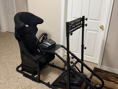 Black Racing Simulator Cockpit with Steering Wheel, Pedals, and Shifter - Immersive Gaming Experience