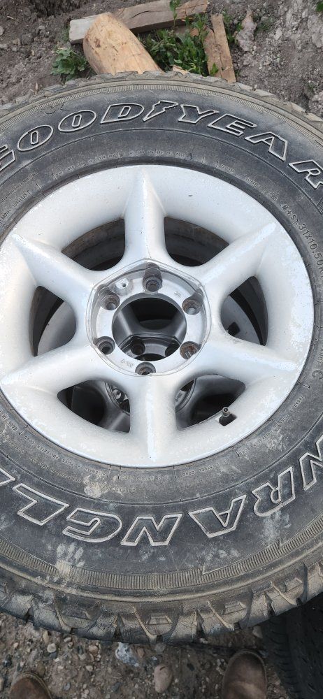 Silver 6-Lug Wheels fit Toyota (Set of 4) with Goodyear Wrangler 31x10.50R15LT Tires.