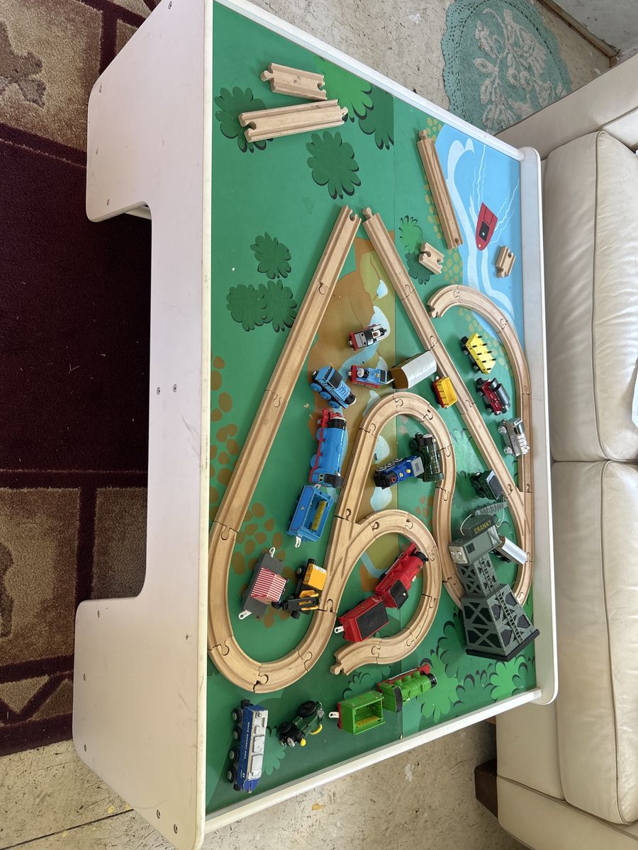 Train table with wooden tracks and trains