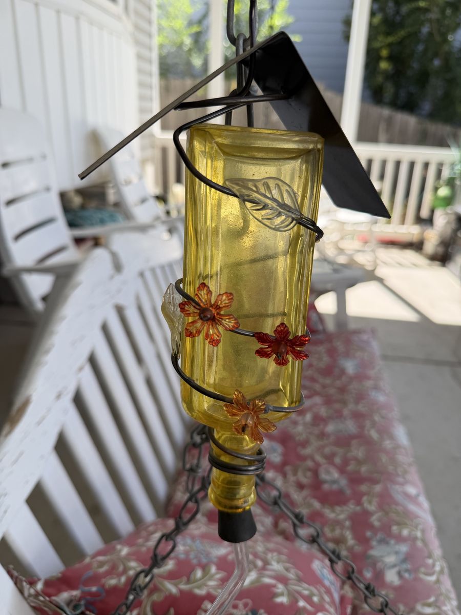 Hanging Yellow Glass Bottle Hummingbird Feeder with Metal Roof and Floral Accents