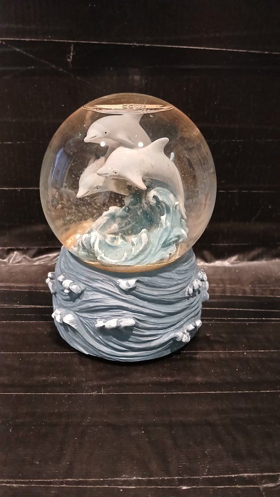 A Westland Musical Dolphin Snow Globe with Wave Base - Ocean-themed Decorative Collectible and it plays EBB Tide